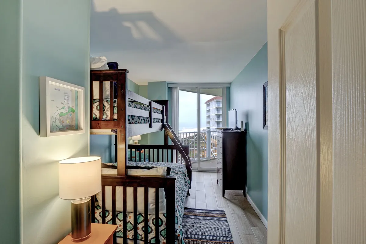 A cozy bedroom with a Twin/Full bunk bed, cheerful bedding, and a television. Soft lighting and inviting colors create a family-friendly, playful atmosphere, perfect for children or families seeking comfort and fun. The space feels bright and welcoming.